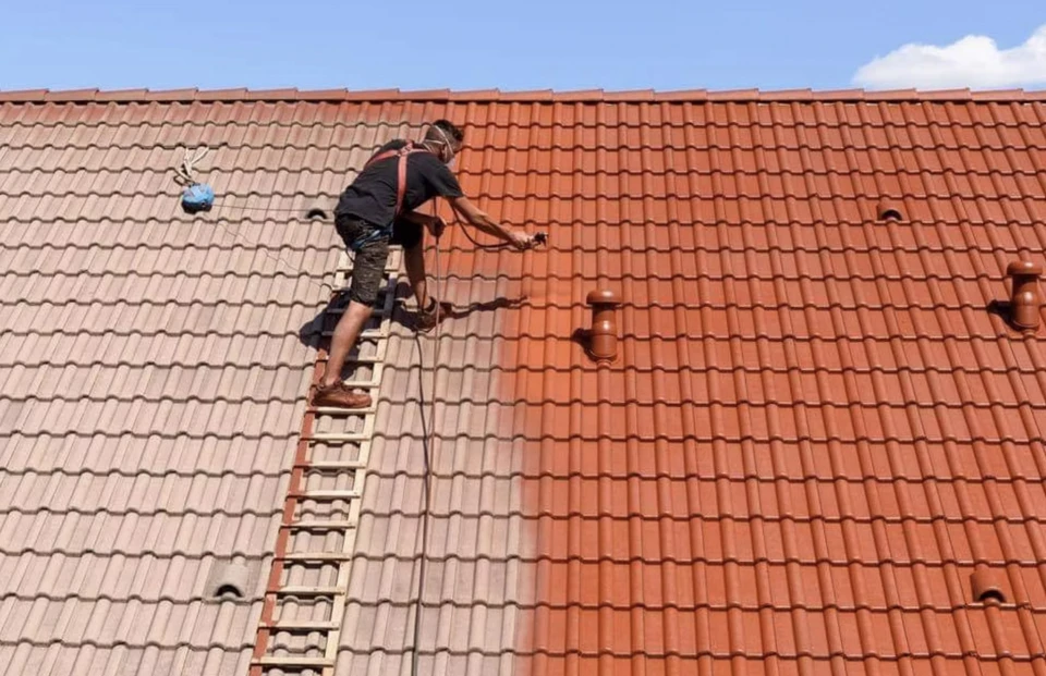 Réparer et remplacer l'ancien toit par un nouveau. Ouvrier de construction en vêtements de protection sur le toit avec des outils.