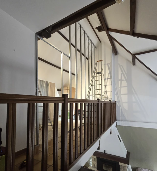 Cuisine moderne avec îlot central et meubles bas anthracite, plan de travail en stratifié imitation bois. Sol en carrelage grand format aspect parquet chêne clair posé en chevrons. Électroménager encastré, crédence carrelage métro blanc. Éclairage LED intégré sous meubles hauts.