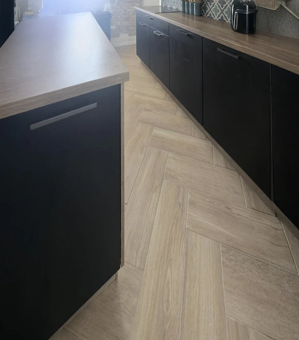 Chantier de rénovation intérieur avec mur en pierre apparente et isolation thermique. Panneaux isolants Rockwool fixés sur ossature métallique, finition placo-plâtre en cours. Sol protégé, outillage de chantier visible.