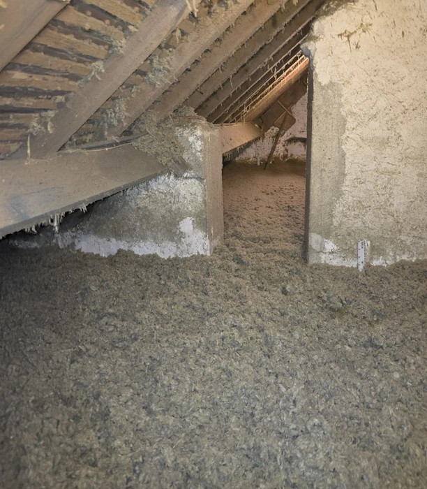 Chantier de toiture en cours, vue extérieure montrant la pose progressive de tuiles terre cuite sur structure bois. Ouvrier au travail sur couverture résidentielle.